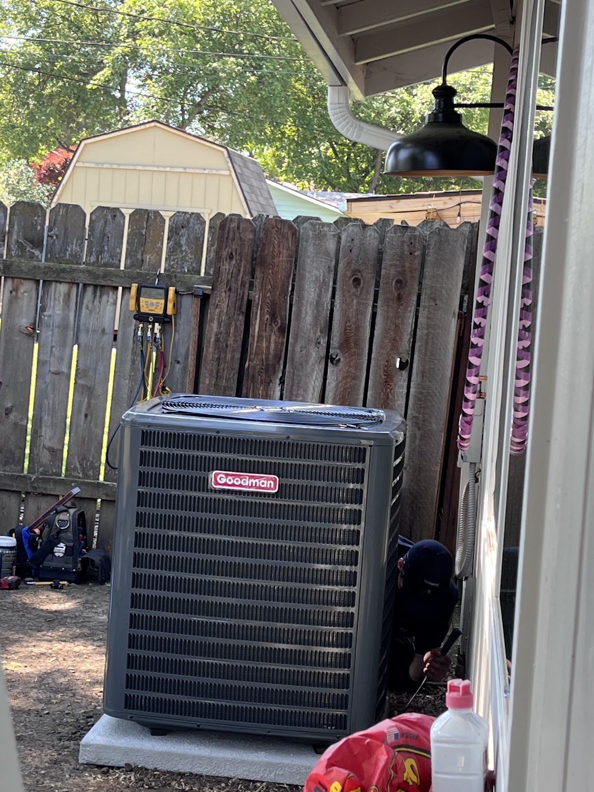 Baumer's Heating & Air technician servicing a Goodman condenser unit